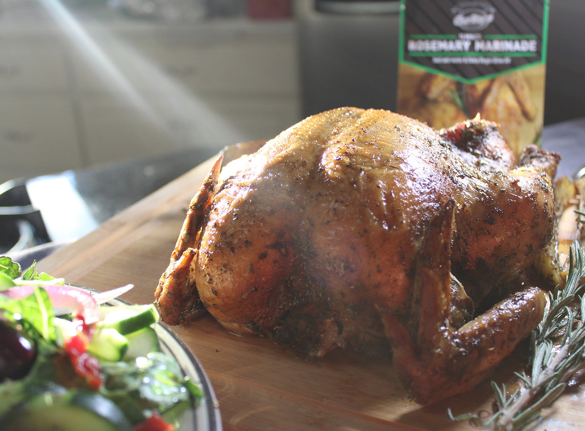 Roast chicken with a CharBoy's Rosemary Marinade packet on a wooden board