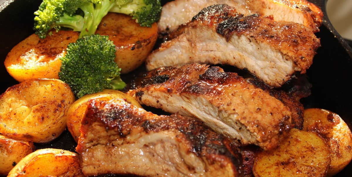Smoky Homestyle baby back ribs roasted with potatoes and broccoli in a cast-iron pan